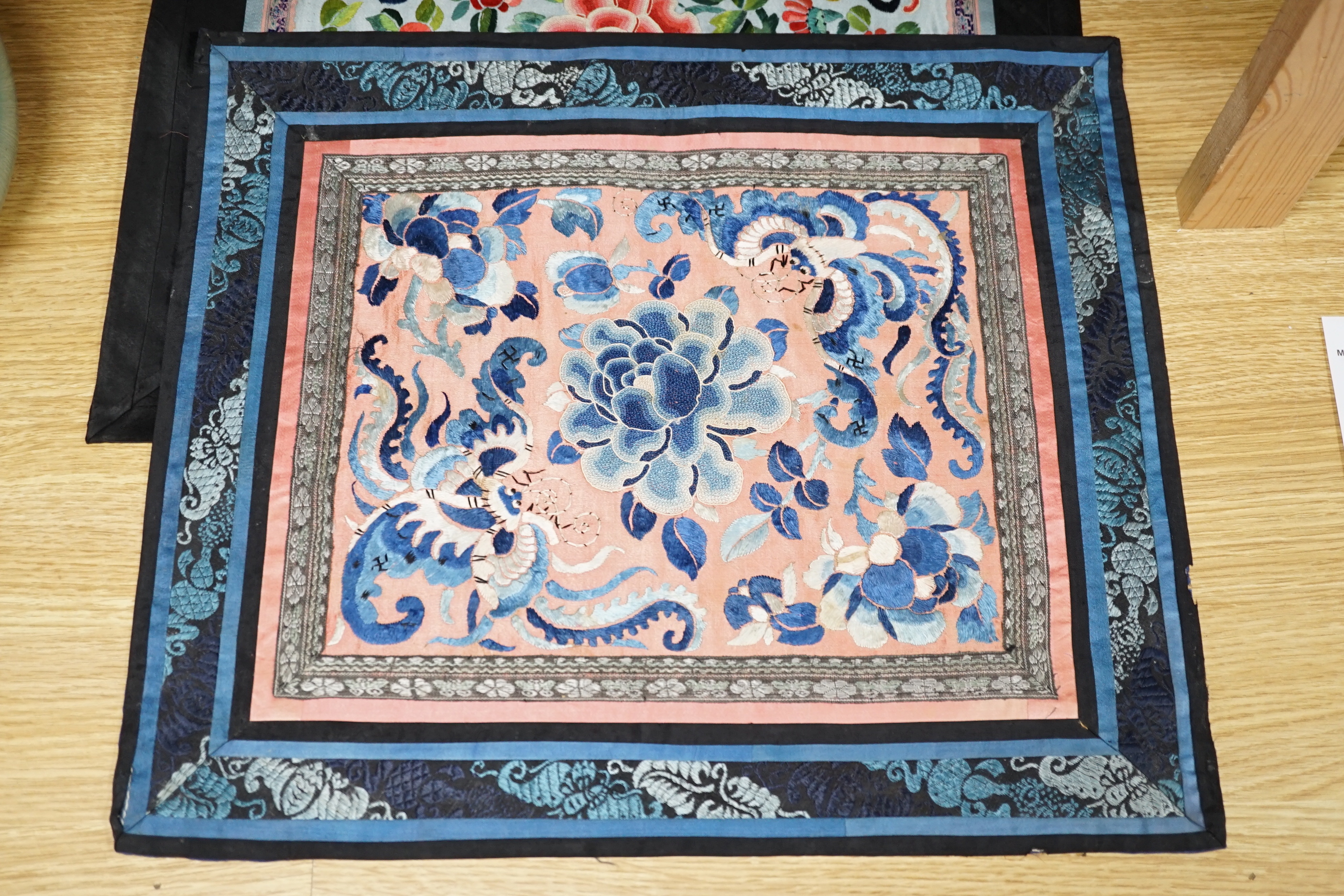 Six Chinese silk mats, embroidered with silk polychrome thread, all using mixed stitches including Beijing knot, five bordered with silk brocade, largest 43cm wide x 37cm high